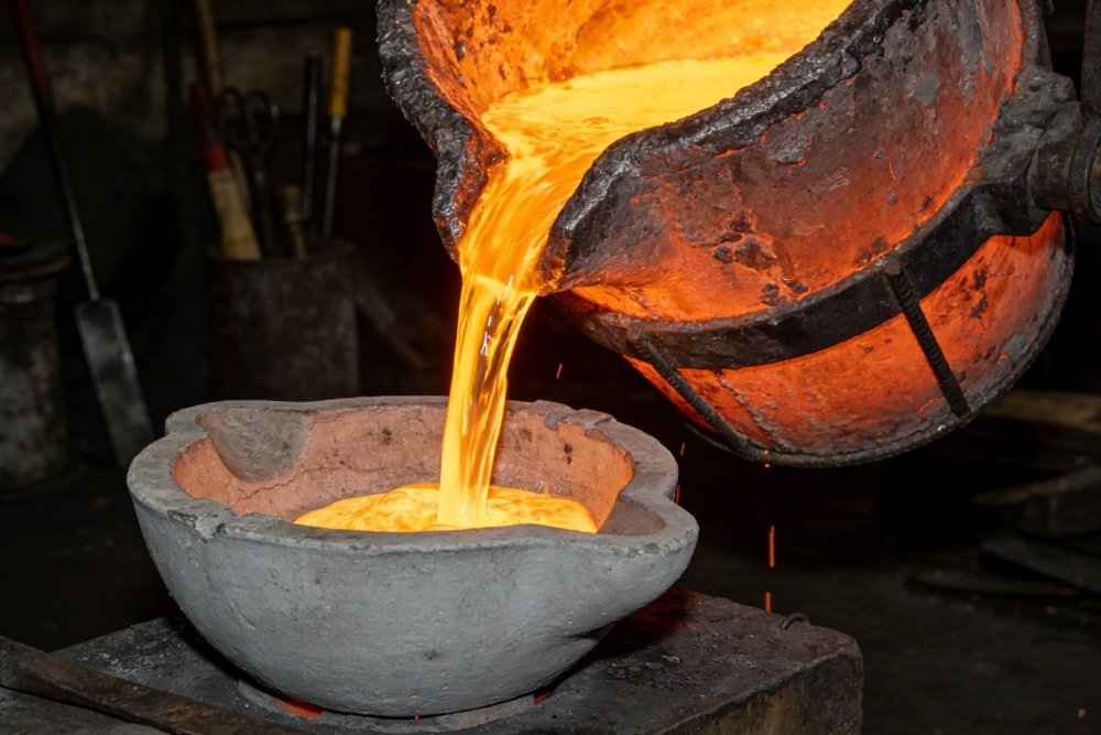 Molten bronze being poured into a ceramic shell during the lost-wax casting process.