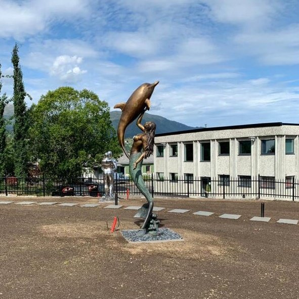 Large bronze mermaid and dolphin sculpture installed for a hotel or resort project in the USA
