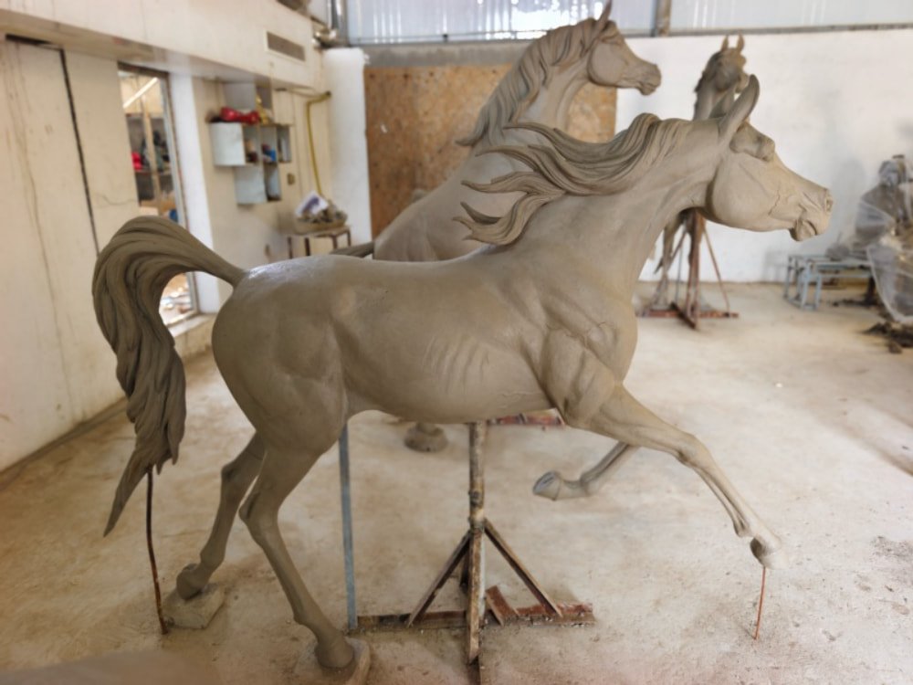 Artisan creating a detailed clay model for a bronze sculpture