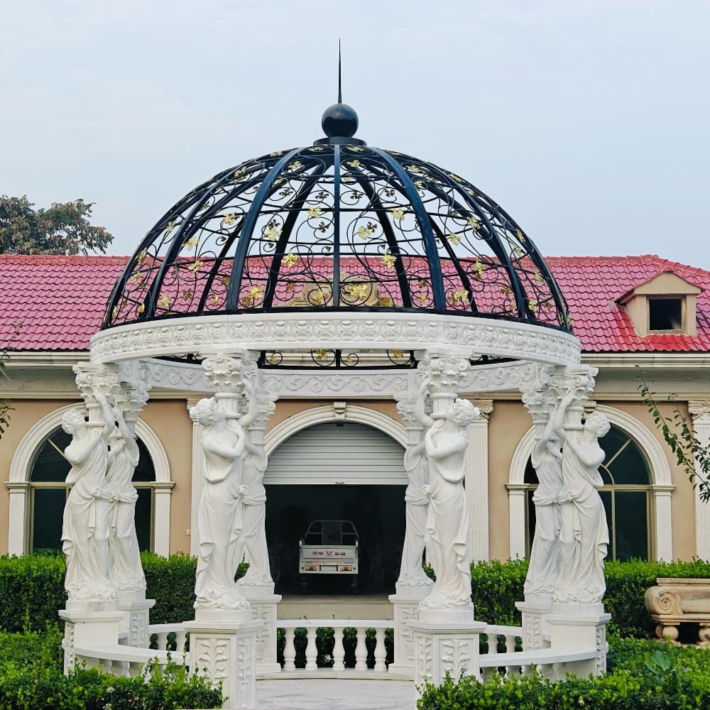 Hand-carved white marble statue gazebo showing statue columns, railings and an iron roof